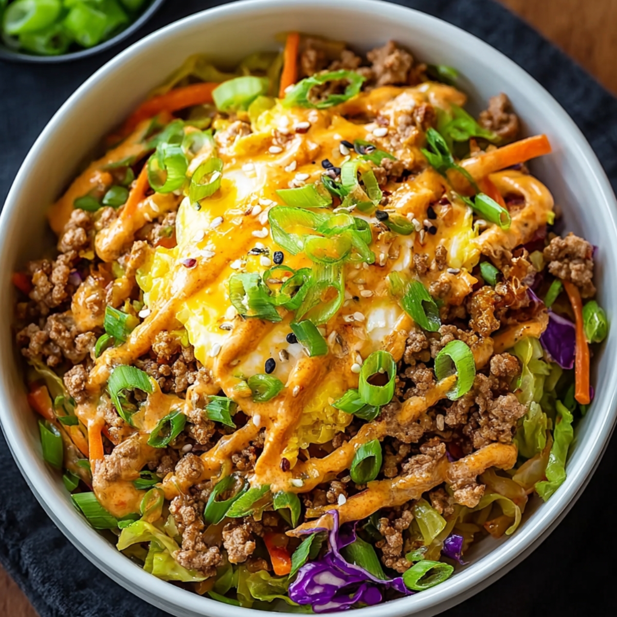 A homemade version of egg roll in a bowl, highlighting fresh vegetables and meat stir-fried together.