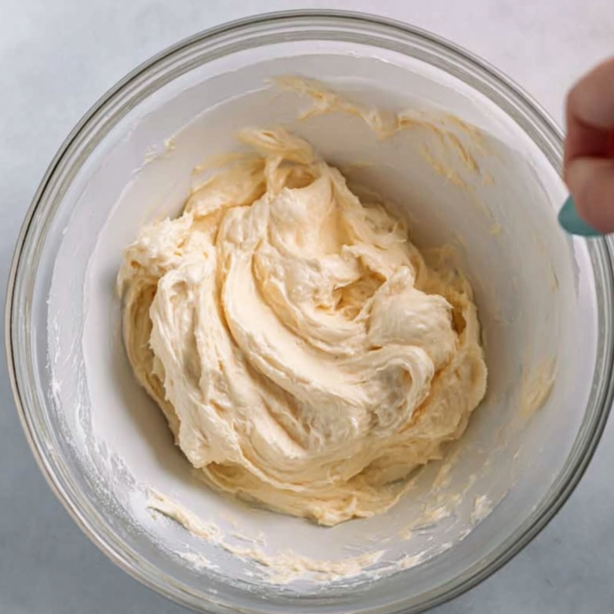 Freshly made buttercream frosting with a smooth, fluffy consistency, perfect for decorating the Brown Sugar Chai Cake. The frosting is light and airy, ready to be applied in beautiful swirls