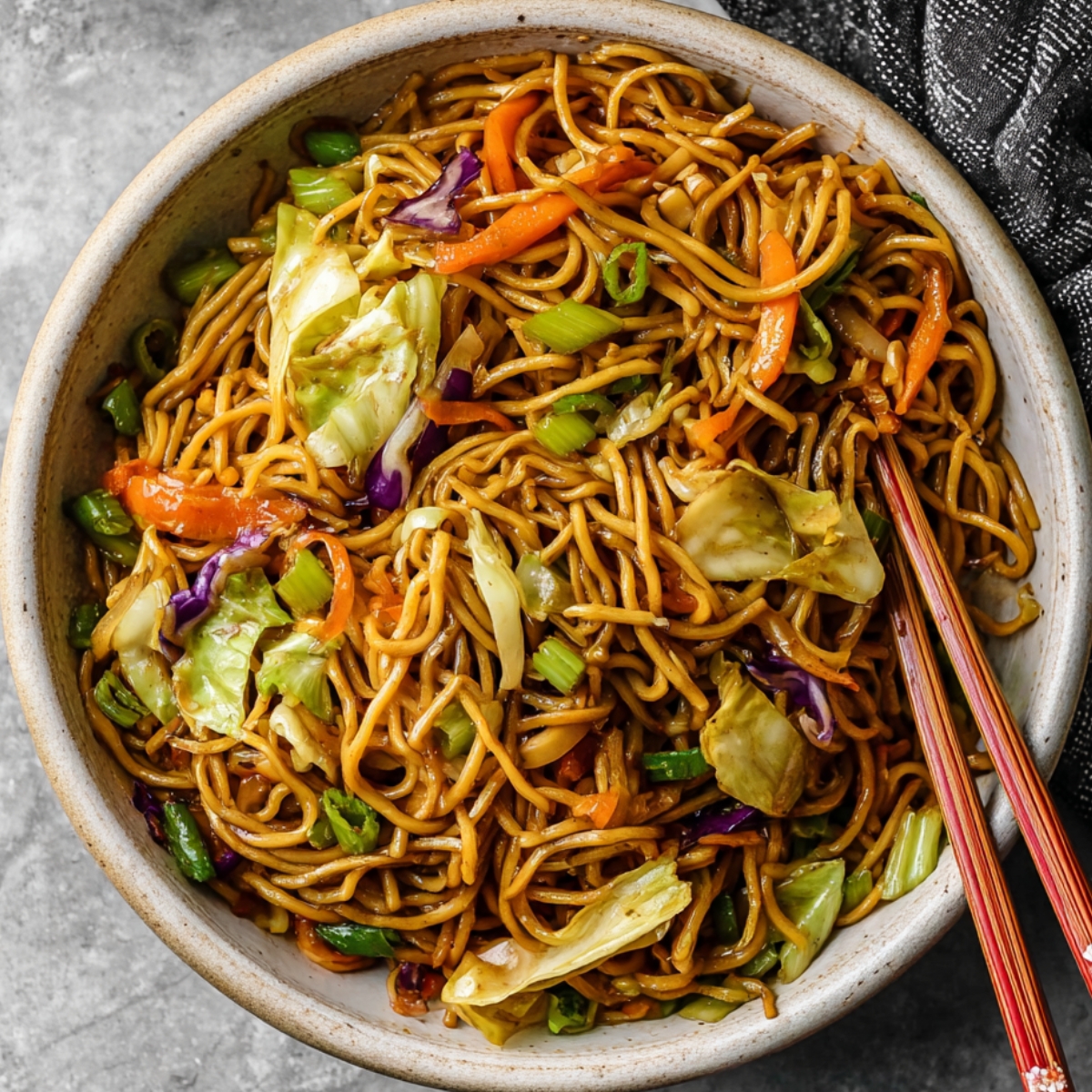 Chow Mein A vibrant bowl of chow mein, brimming with colorful vegetables like cabbage, carrots, and green onions, nestled in savory noodles. A perfect balance of flavors and textures, making this an irresistible stir-fry dish