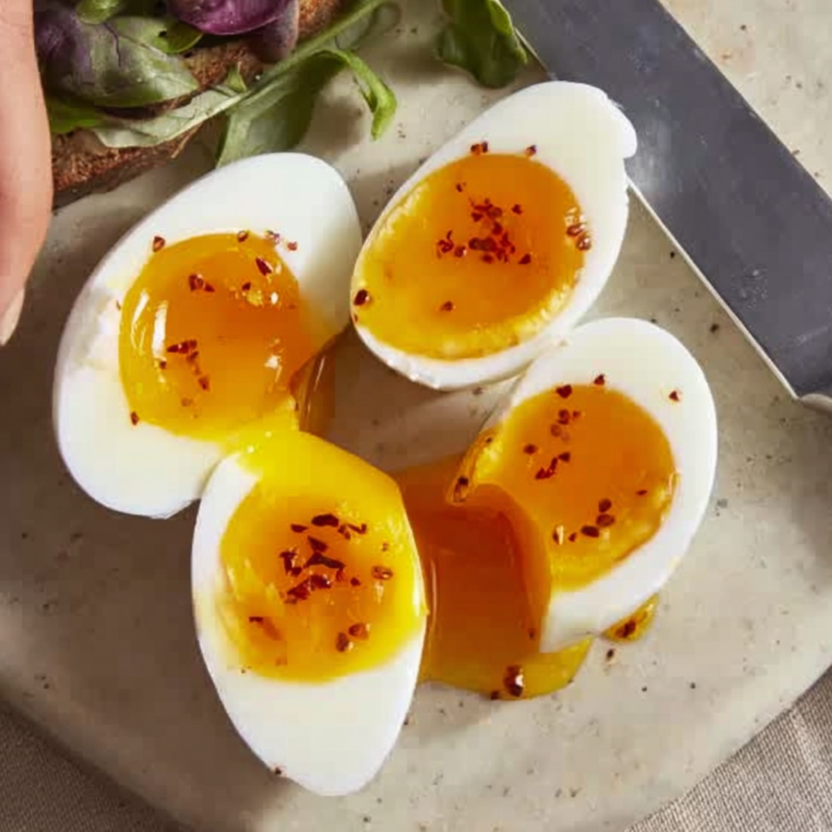 Soft-boiled eggs with a perfectly runny yolk, seasoned with chili flakes for a bit of spice. The rich, golden yolk contrasts beautifully with the creamy white, making it the perfect addition to a salad, toast, or as a simple, nutritious snack.