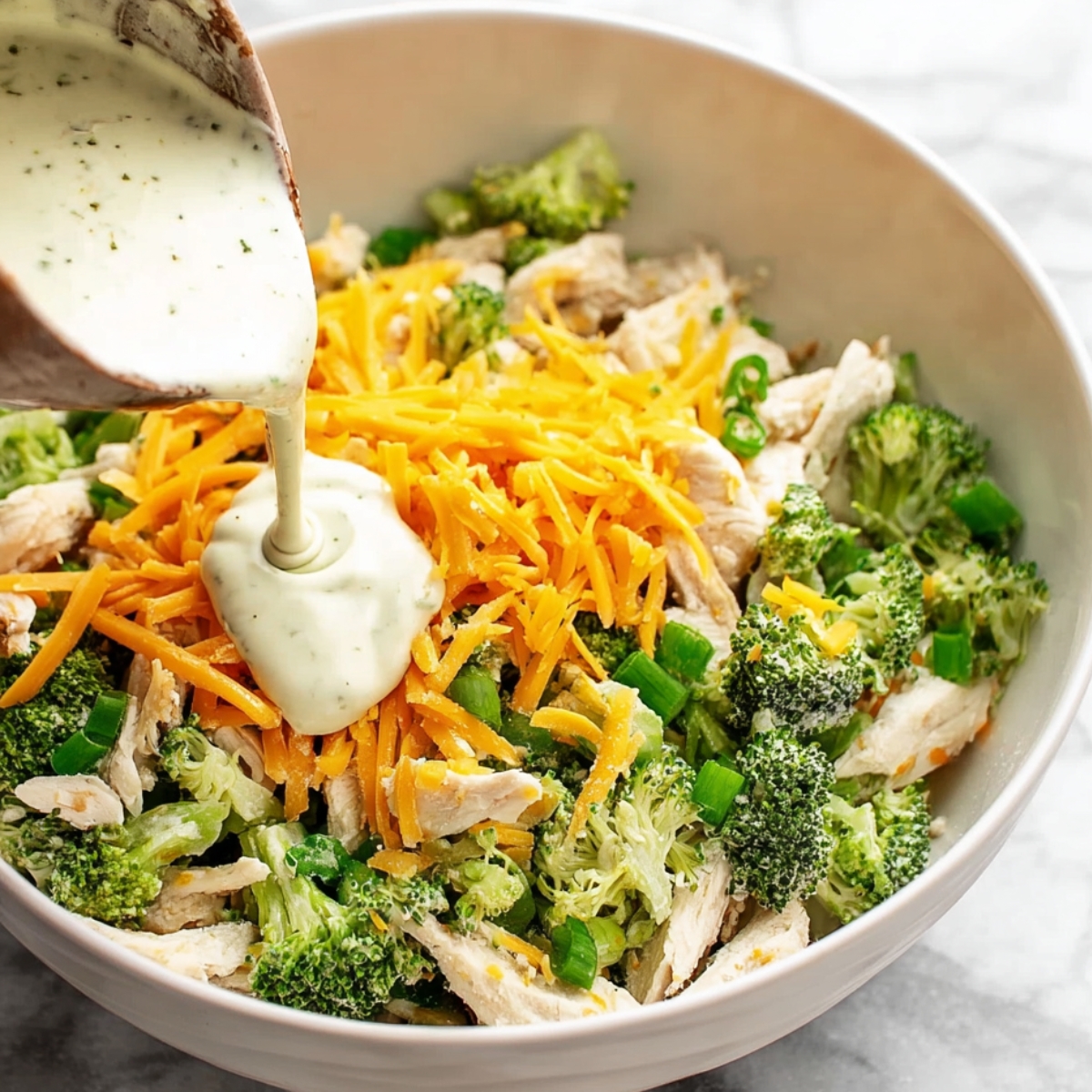 Drizzling on the creamy goodness! This ranch dressing adds the perfect touch to your broccoli cheddar chicken salad. #RanchLover #FreshFlavo