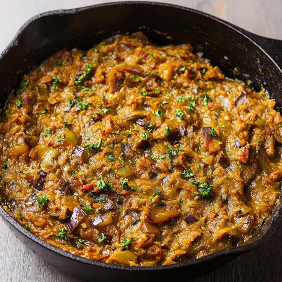 Close up of a delicious mashed eggplant curry served over fluffy rice, topped with fresh cilantro, creating a rich and comforting meal.