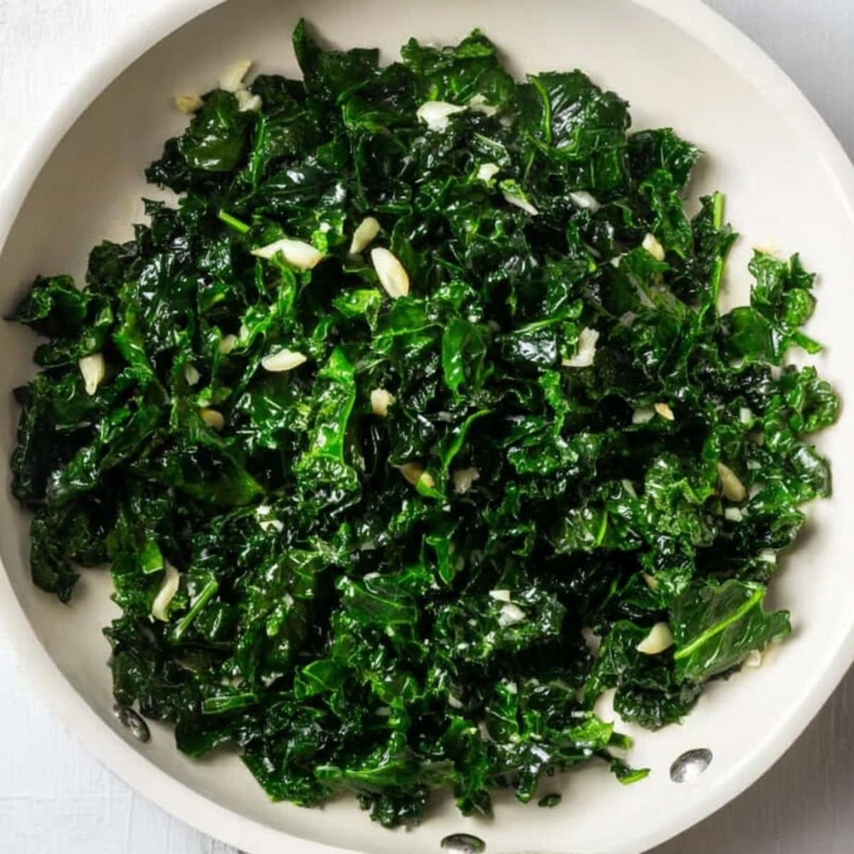 Sautéed Kale with Garlic: A close-up shot of vibrant, sautéed kale, lightly cooked with garlic. The kale is dark green, tender, and has a slight sheen, indicating it was sautéed in oil or butter, making it a healthy and flavorful side dish.