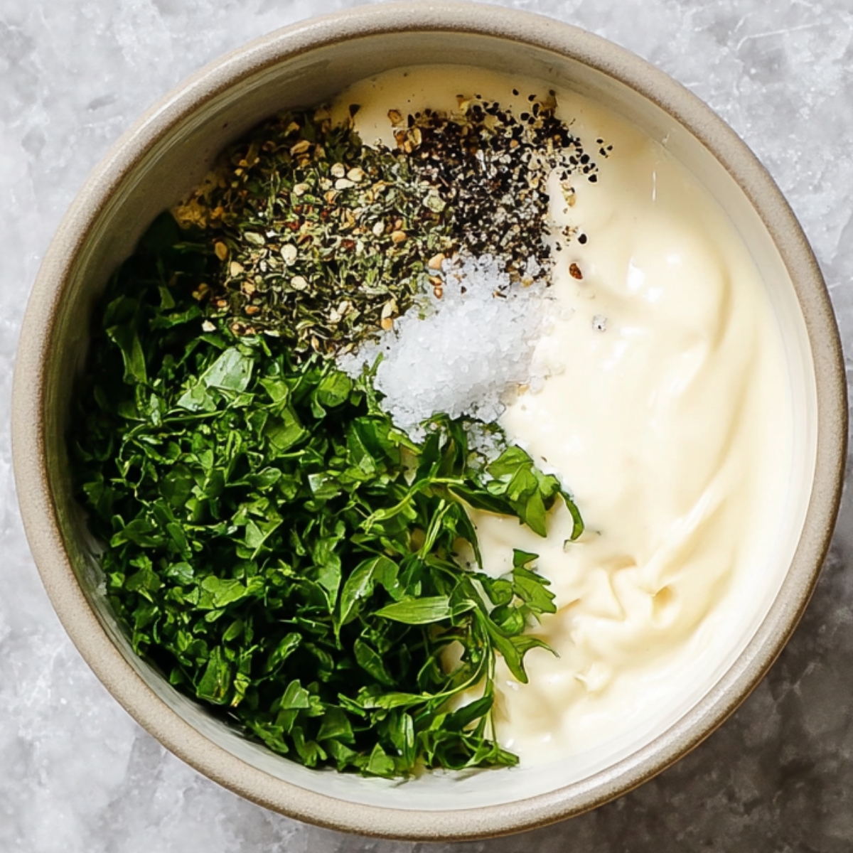 Dressing Ingredients Close-Up: A small bowl of creamy dressing ingredients, including mayonnaise, fresh herbs, salt, and black pepper, all set to create a flavorful dressing to complement the salad.