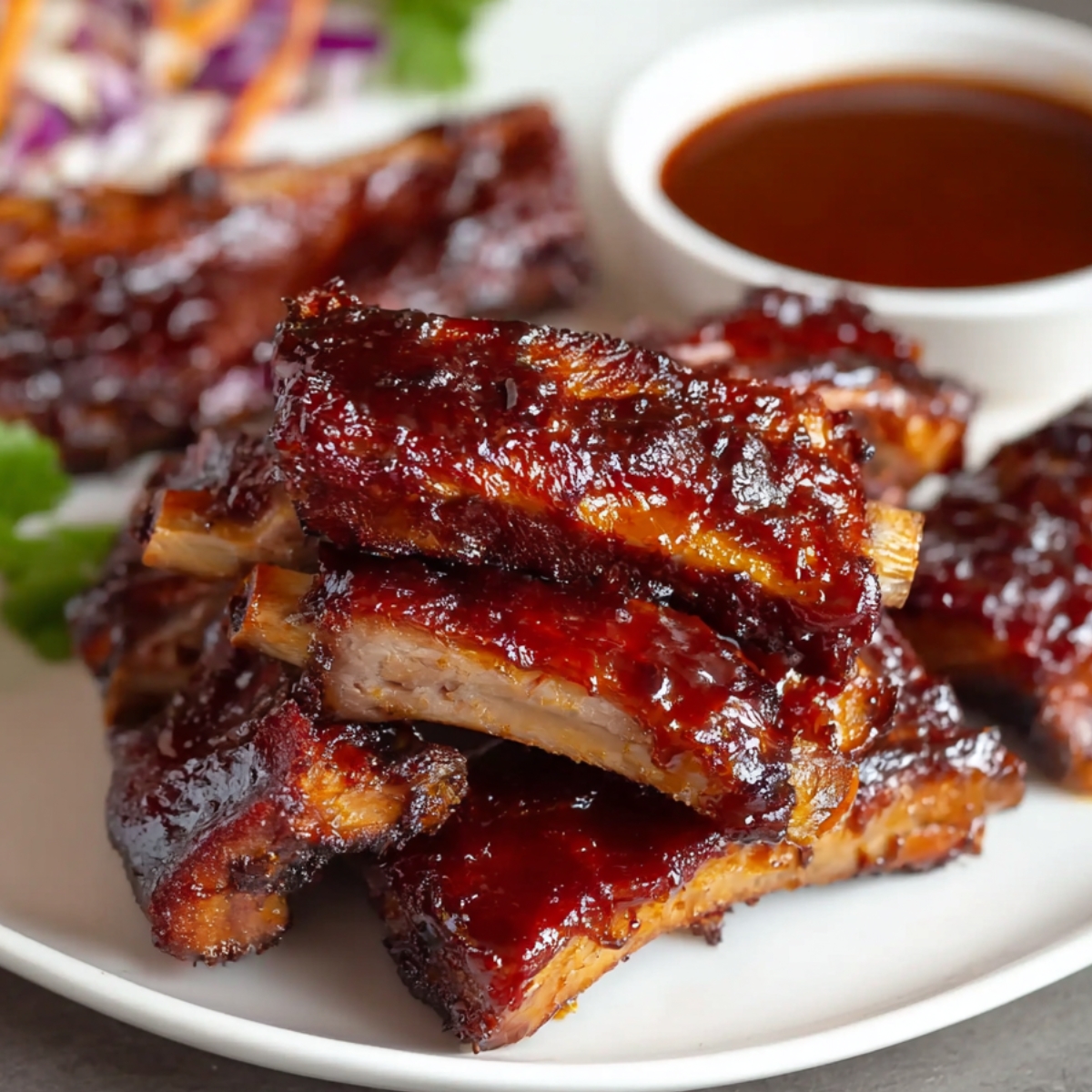 BBQ Ribs Recipe Close up of delicious BBQ ribs with a thick, glossy sauce, stacked high and ready to be enjoyed