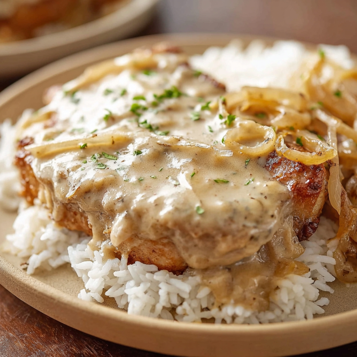 smothered pork chops Creamy smothered pork chops over fluffy white rice, topped with rich onion gravy — the ultimate comfort food!