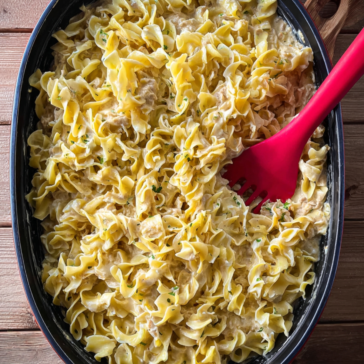 Mixing cooked egg noodles into the rich, creamy tuna sauce easy step for a hearty and comforting casserole.